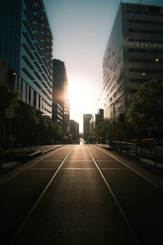 the sun is shining brightly down the city street