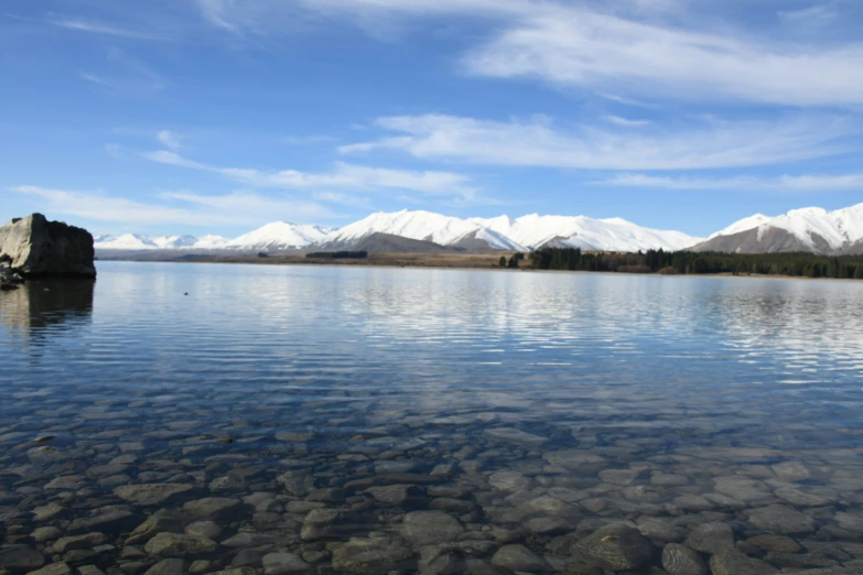 a mountain lake surrounded by mountains under a blue sky