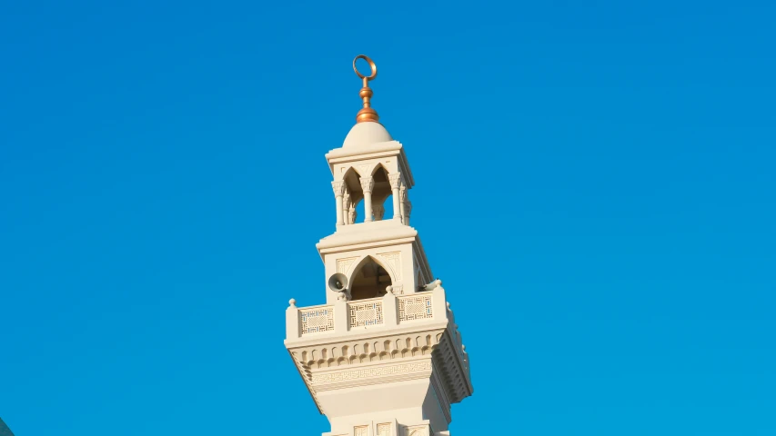 a white clock tower with a golden top