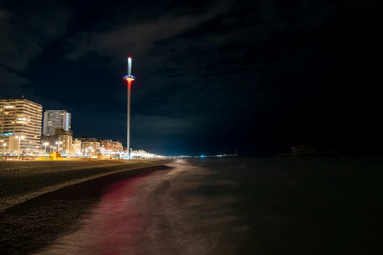 a dirt road next to water with light houses