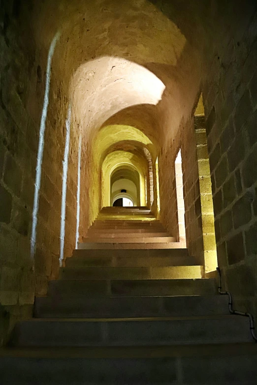 a tunnel with stairs lit by a single light