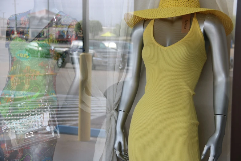 a yellow knit dress sitting next to a display window