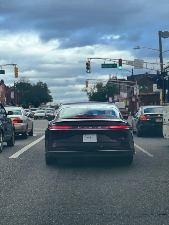 a view of the back end of a car on a city street