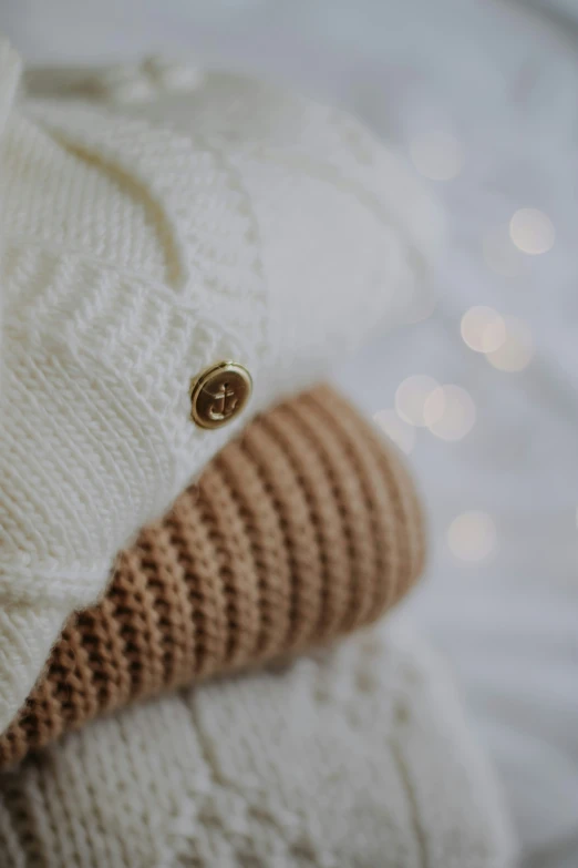 a pile of sweaters are stacked together on the shelf