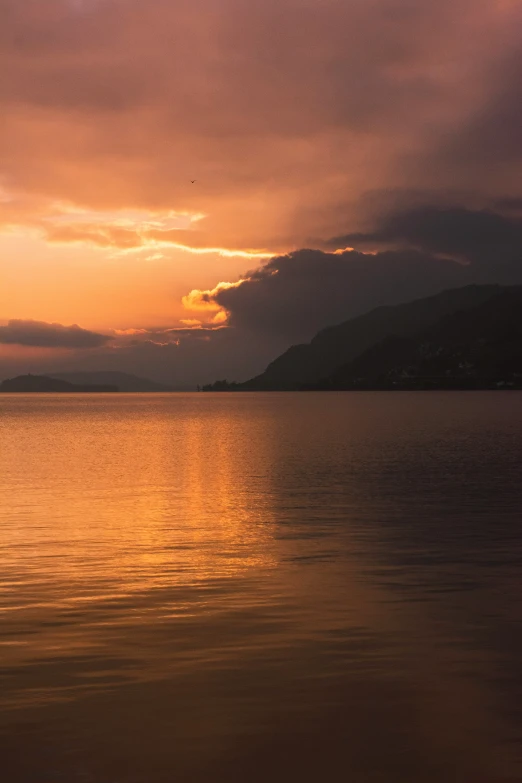 the sky is reflecting off the water at sunset