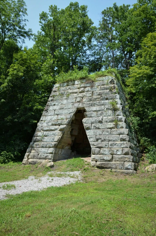 a stone structure sitting in the middle of a forest