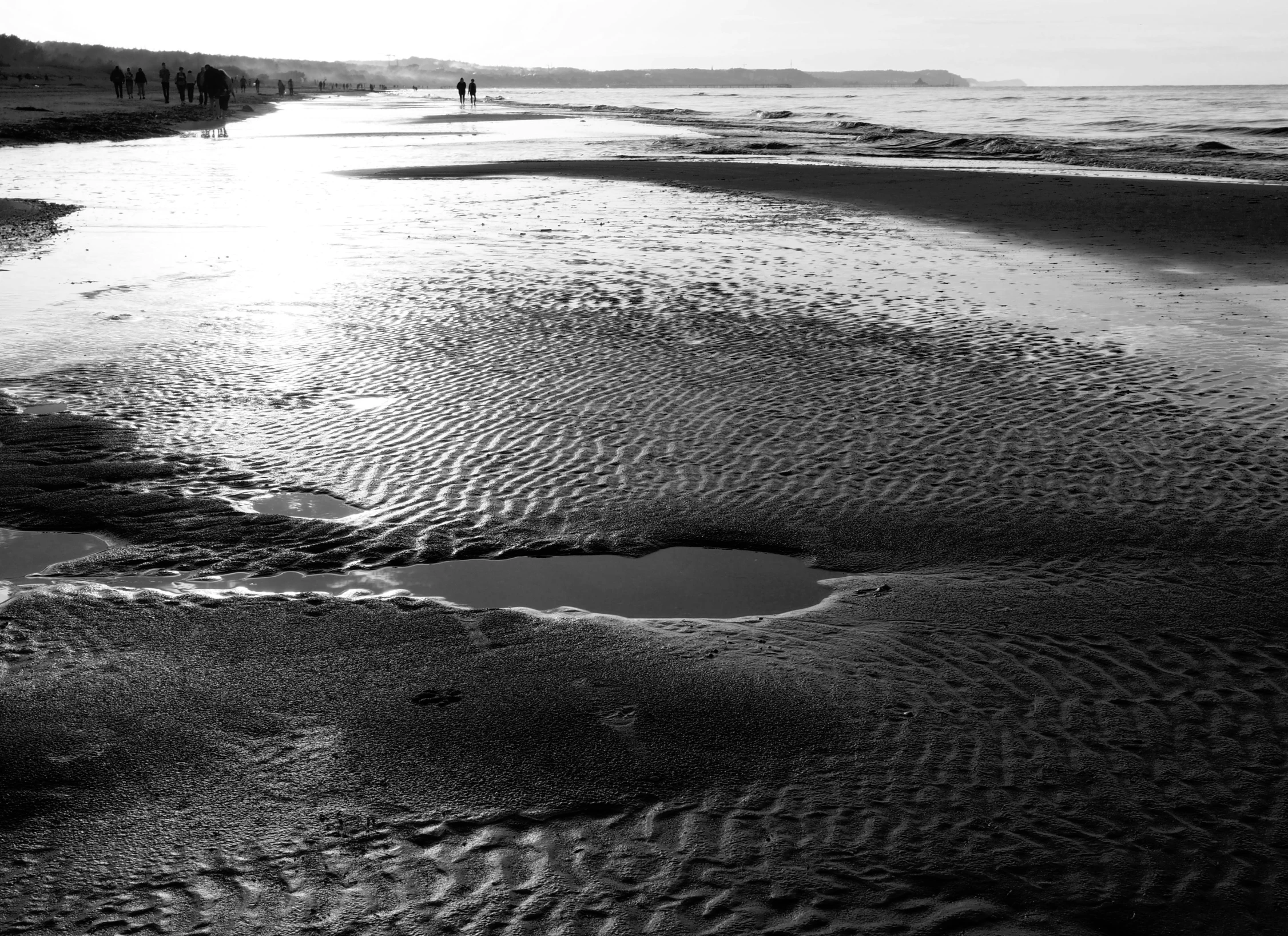 people are walking on the water in black and white