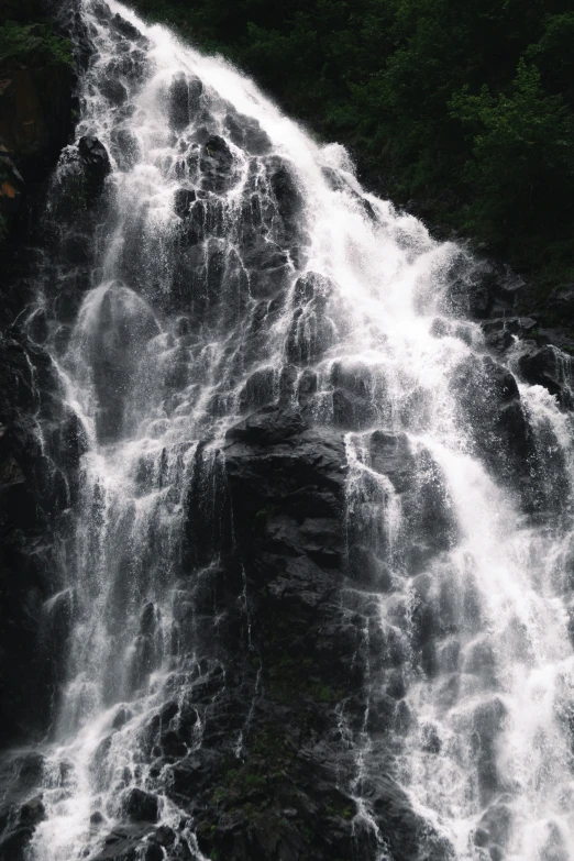 a man standing on top of a waterfall next to a bunch of water