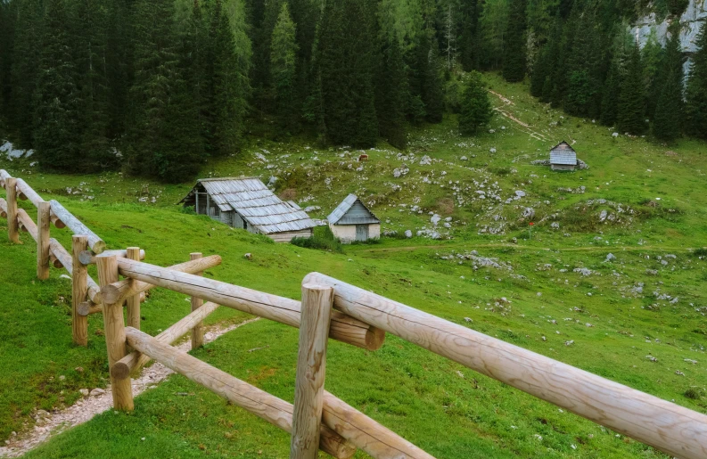 a wooden fence in front of a small cabin