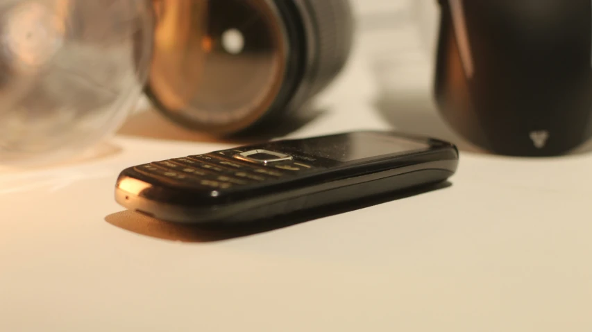 a cellphone sitting on top of a counter next to other items