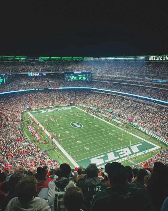 an open stadium that has fans sitting on the seats watching a football game