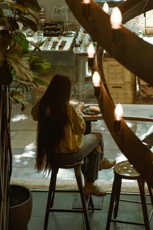 a woman sitting at a table while using a cell phone