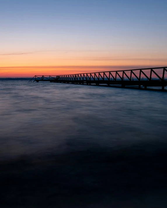 the beach is lined with wooden benches and pier posts