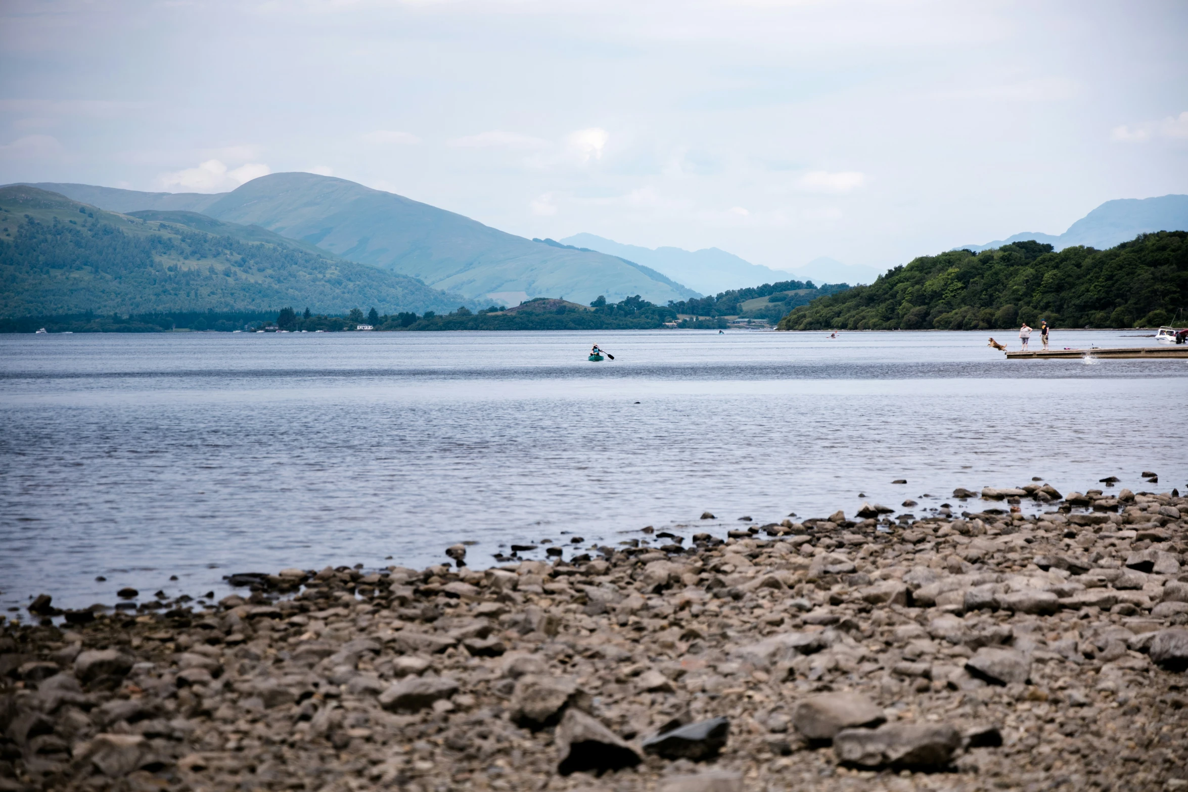 two people in canoes on the river with mountains behind them