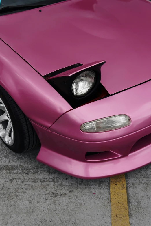 the front end of a pink sports car