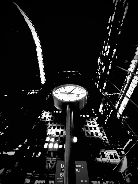 a clock lit up in the middle of a city