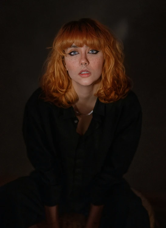 a woman with red hair is sitting down