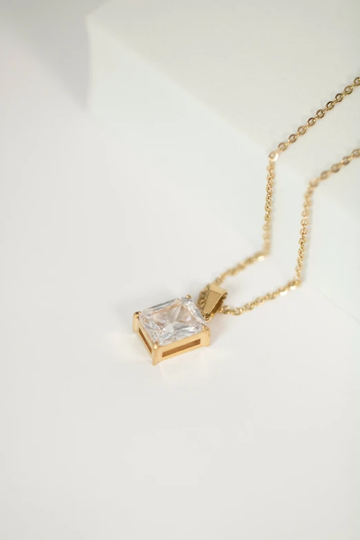 a diamond necklace on a gold plated chain