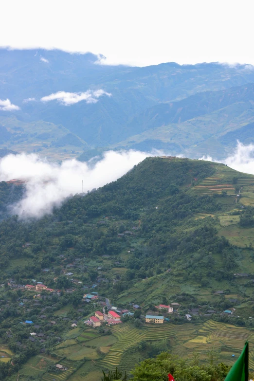 a small village on a large hill surrounded by fog