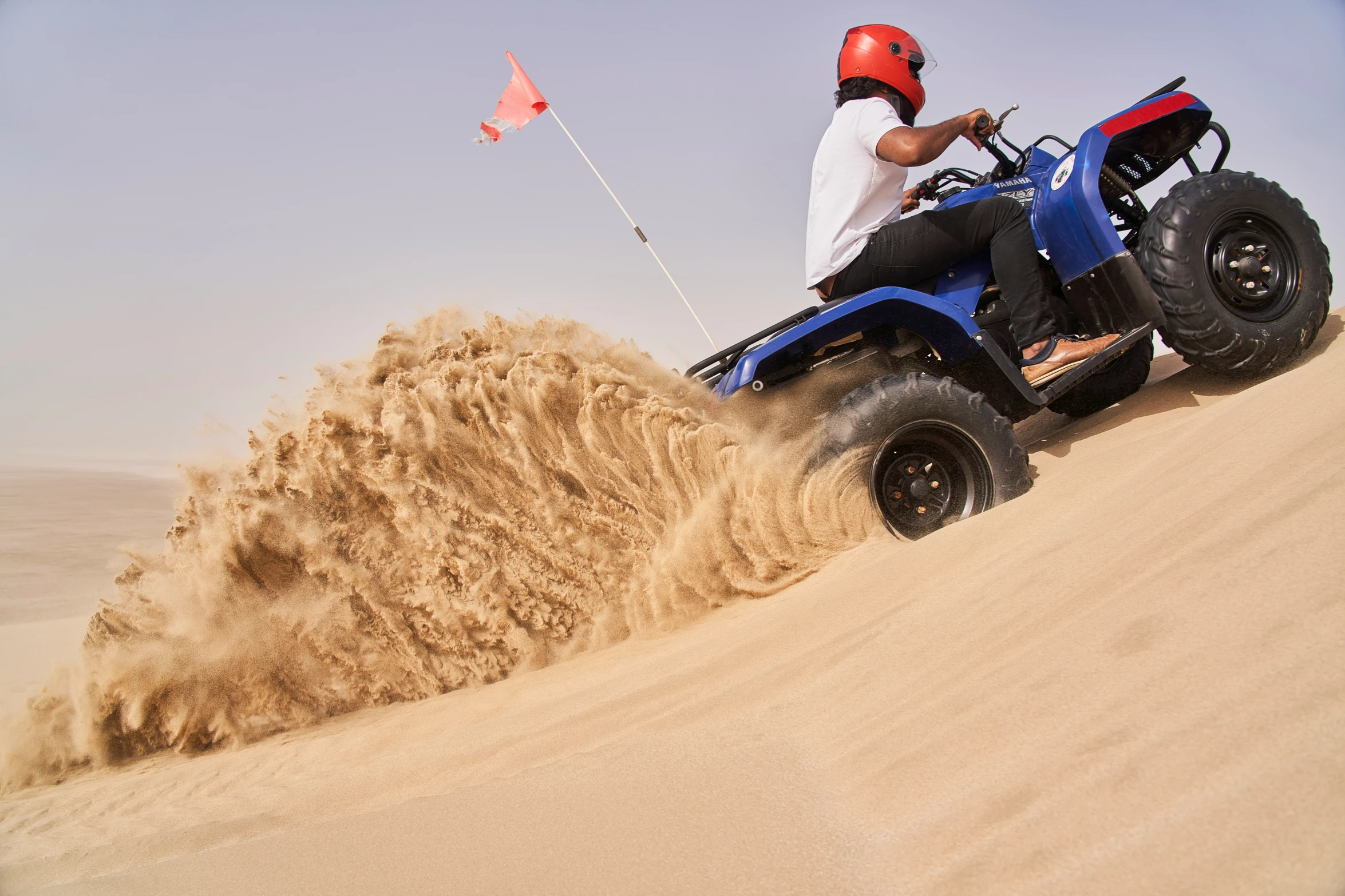 a man riding a four wheeler on top of a sandy beach