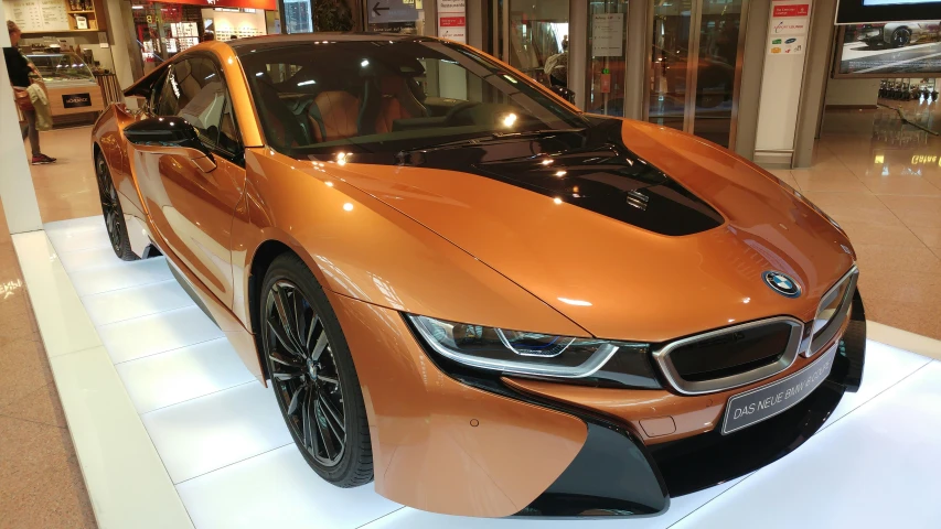 a person stands near an orange bmw concept car