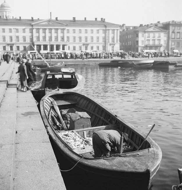 a boat parked at a harbor with a row boat on it