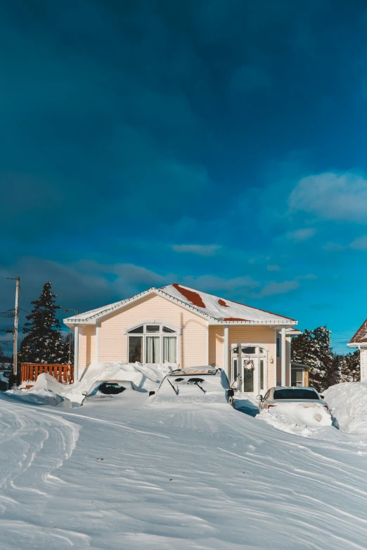 the front of a small white house covered in snow