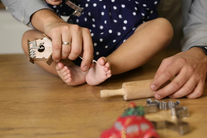 the person is putting tiny beads to a small doll