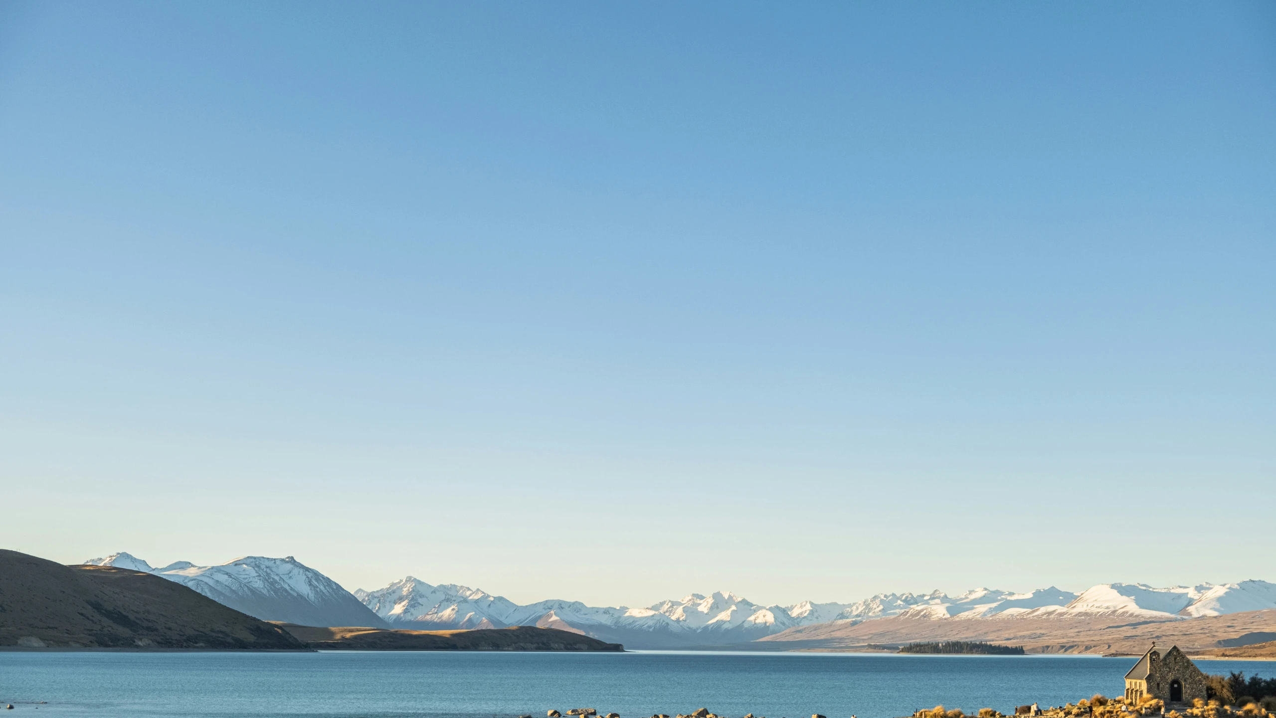 a body of water with mountains in the background