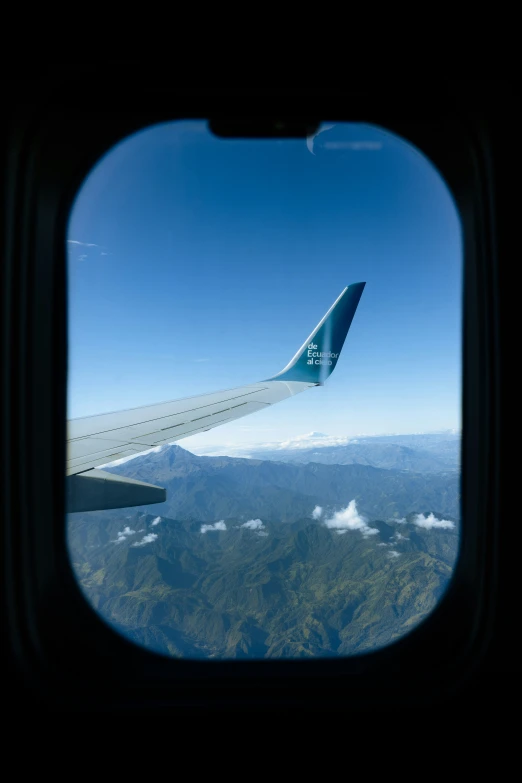 the view from an airplane window shows the mountains and clouds