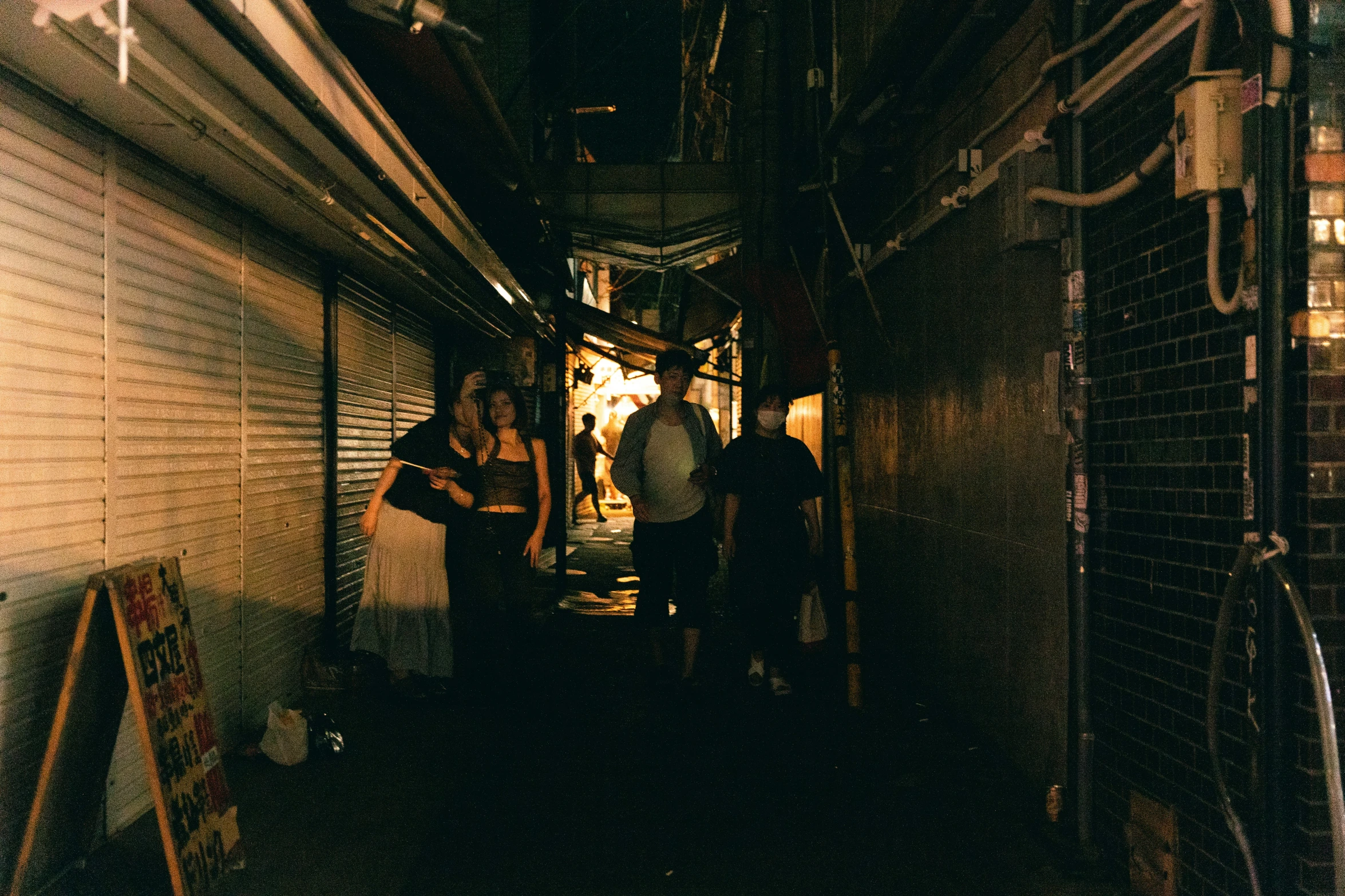 a group of people who are walking in a dark alley