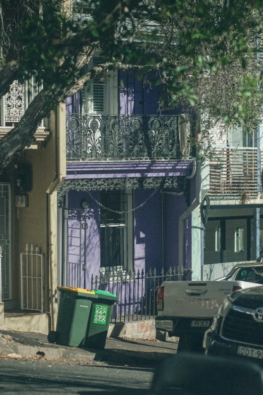 a building with purple shutters and iron railing