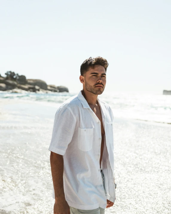 man walking along beach, wearing on down shirt