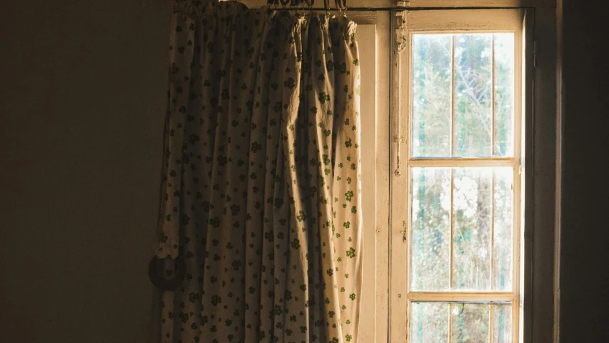 a window is open to a window with curtains and a chair next to it