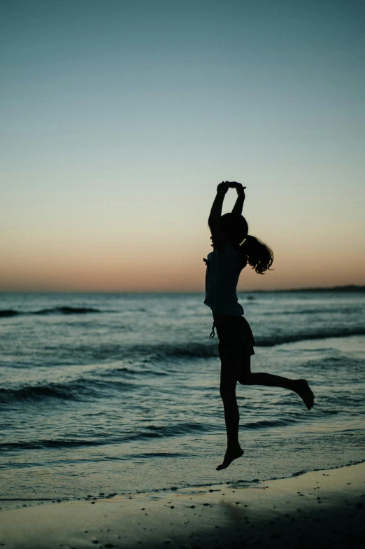 silhouette of the woman standing in front of a body of water