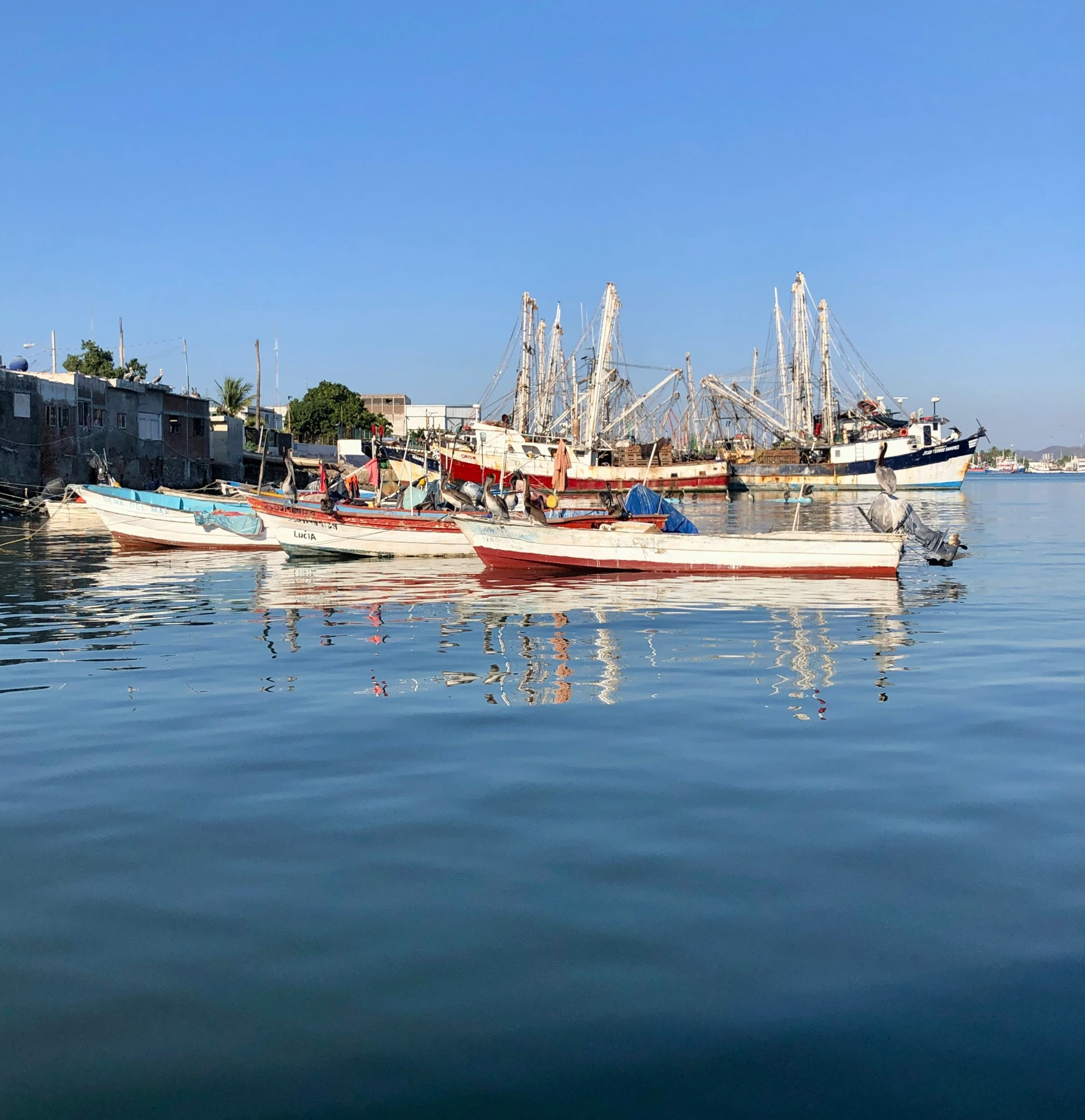 many different boats docked in an industrial area