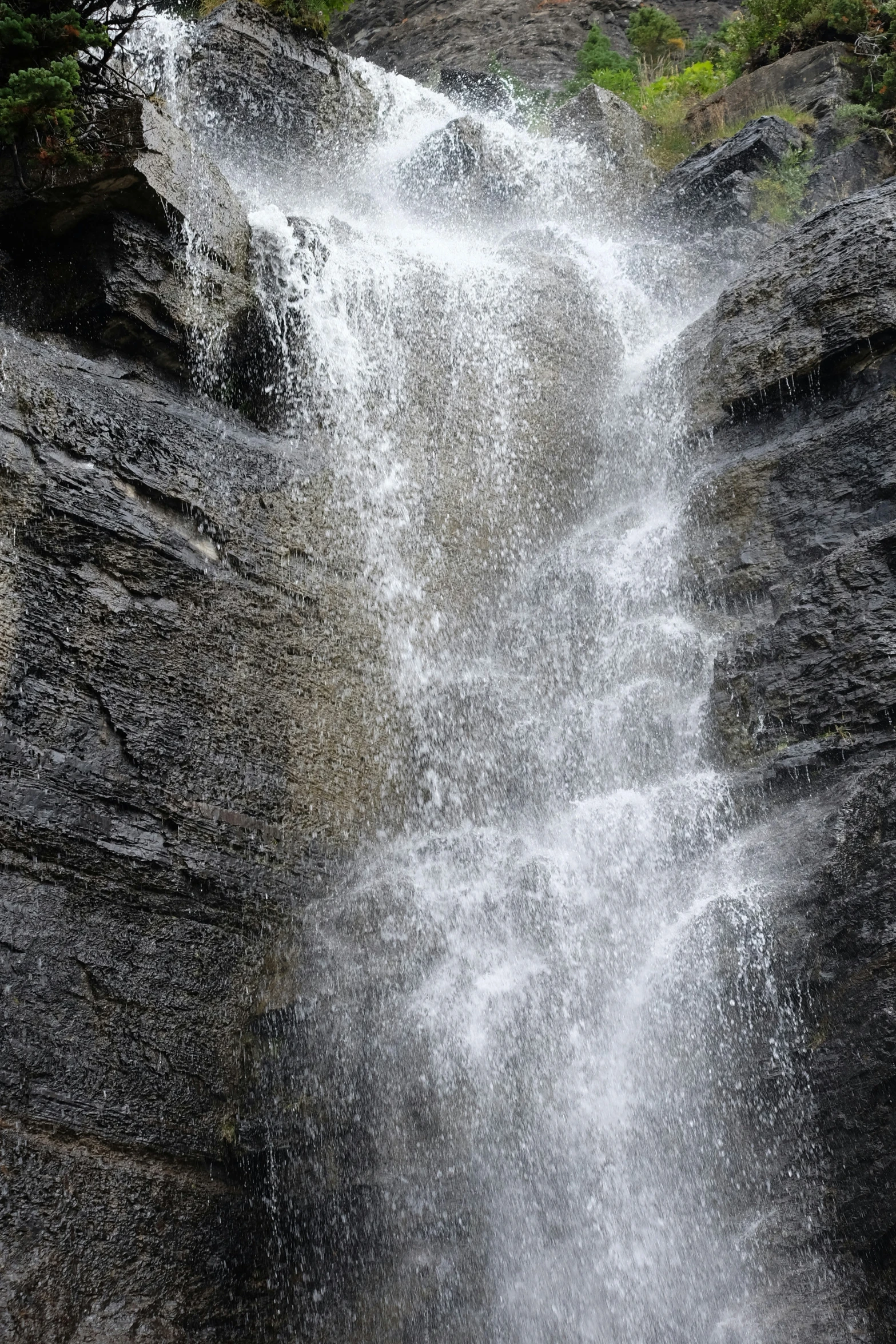 two people climbing up and down a waterfall