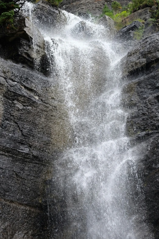 two people climbing up and down a waterfall