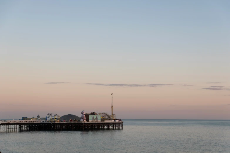 an old boat sits docked on the ocean at dusk