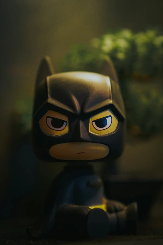 there is a toy batman standing up wearing a batman mask