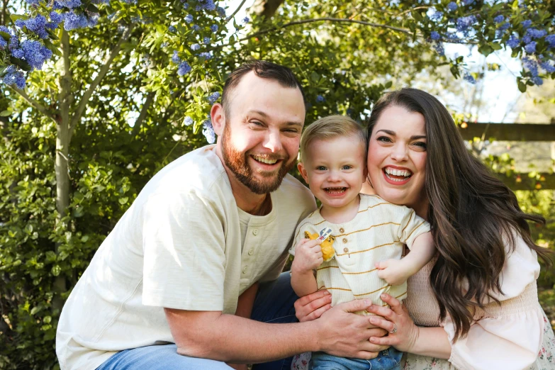 man and two woman pose for picture with their small child