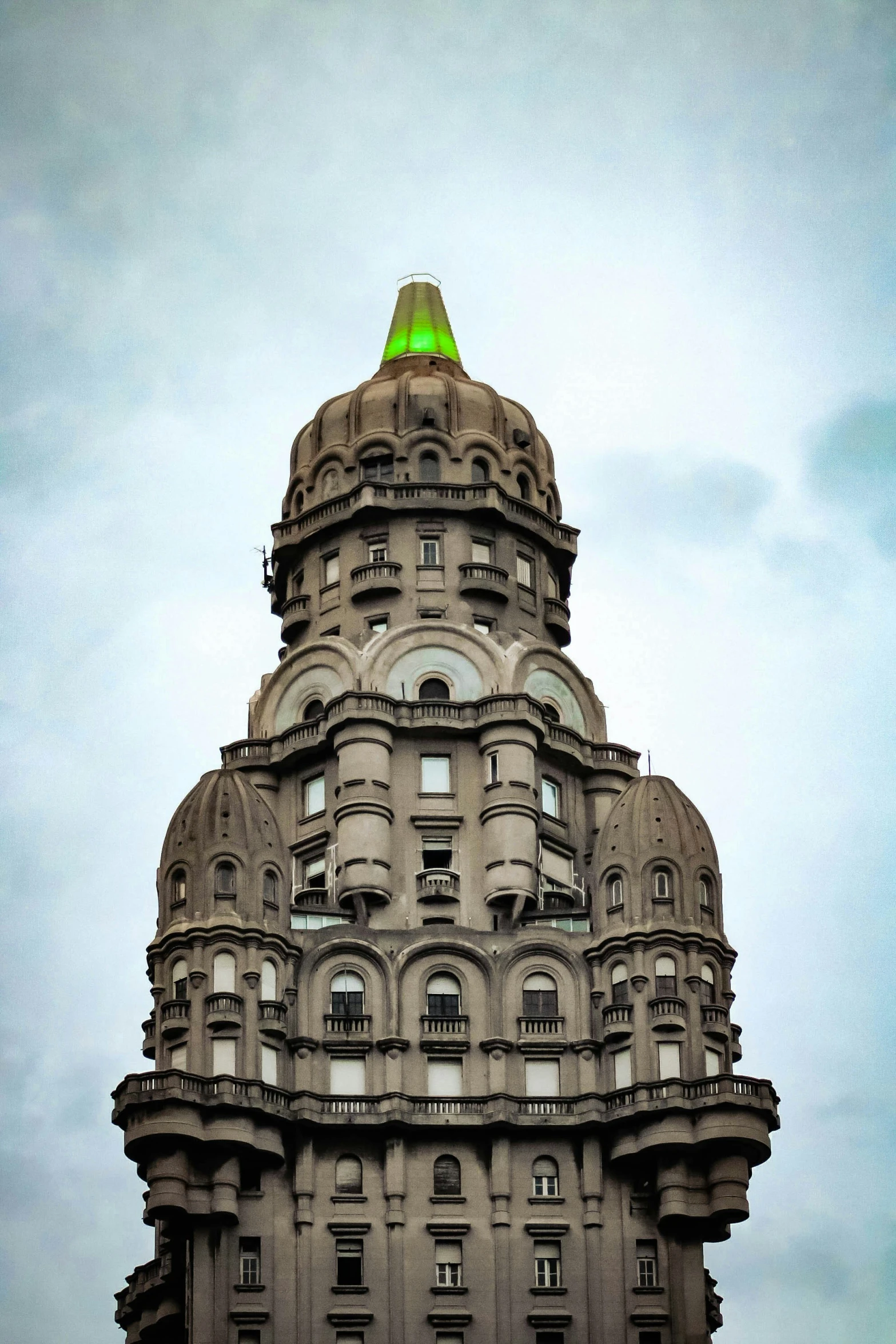 a tall stone building with a green top