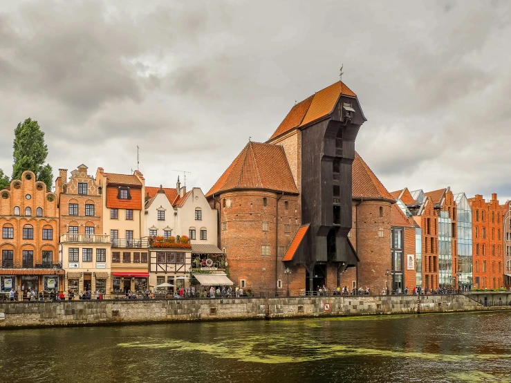 tall building next to river with old town around