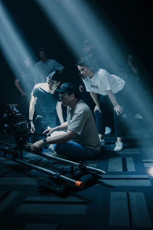 some men behind a camera in front of a stage lighting