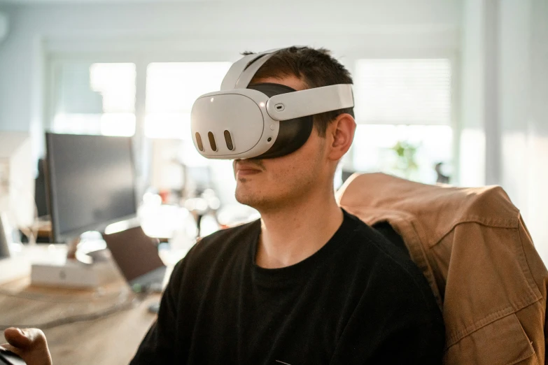 a man in a black shirt is wearing a virtual - reality device