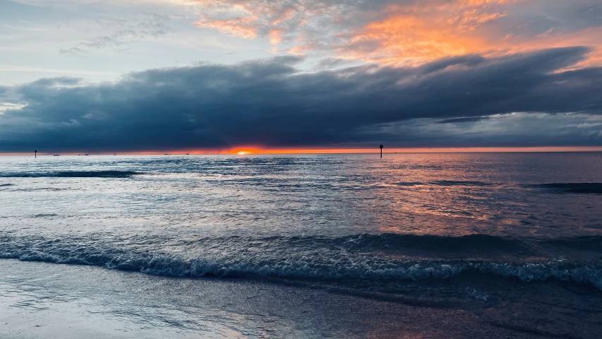 some waves on a beach water and clouds