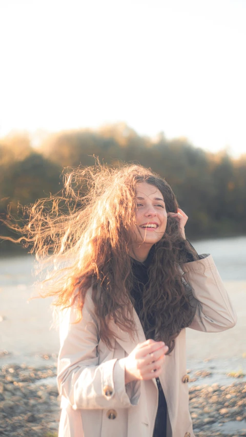 a woman with long hair is walking on a beach