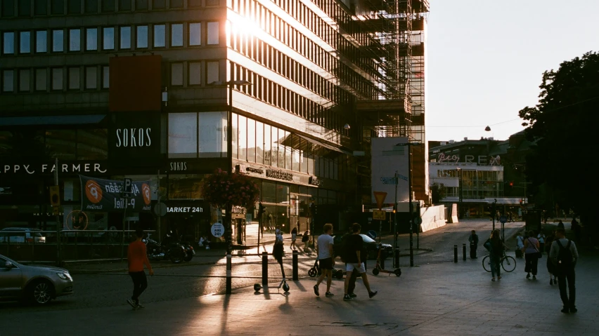 people walking around on the sidewalk in front of a building