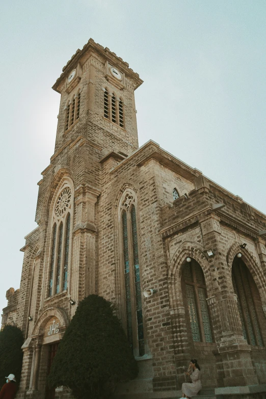 a tall brick building with two towers and a clock on top