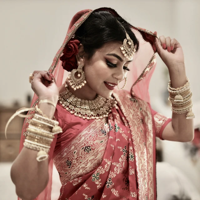 a bride with dark hair is wearing an indian outfit